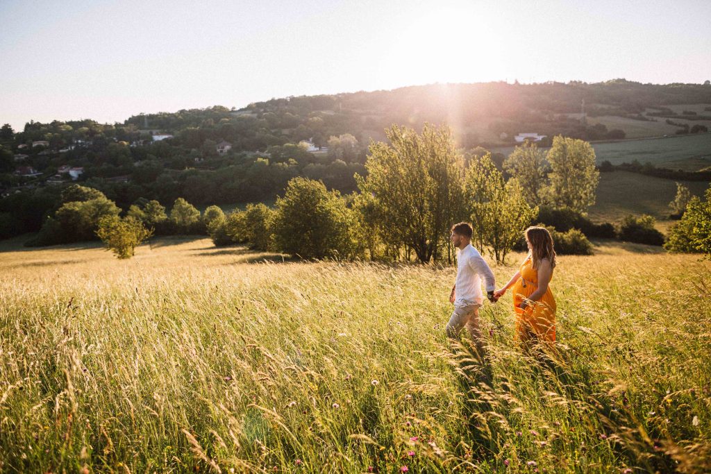 couple marchant sur les sentiers des monts d'or lors d'une séance photo grossesse naturelle