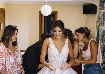 la mariée enfile sa robe au domaine de la ruisselière